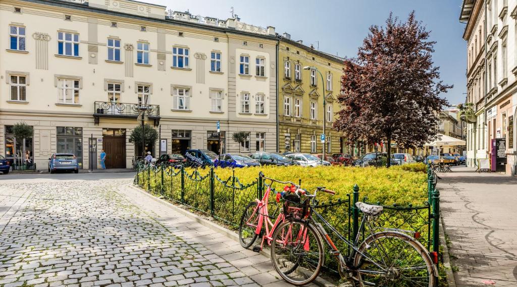 two bikes parked next to a fence on a street at Miodowe mieszkanko in Krakow