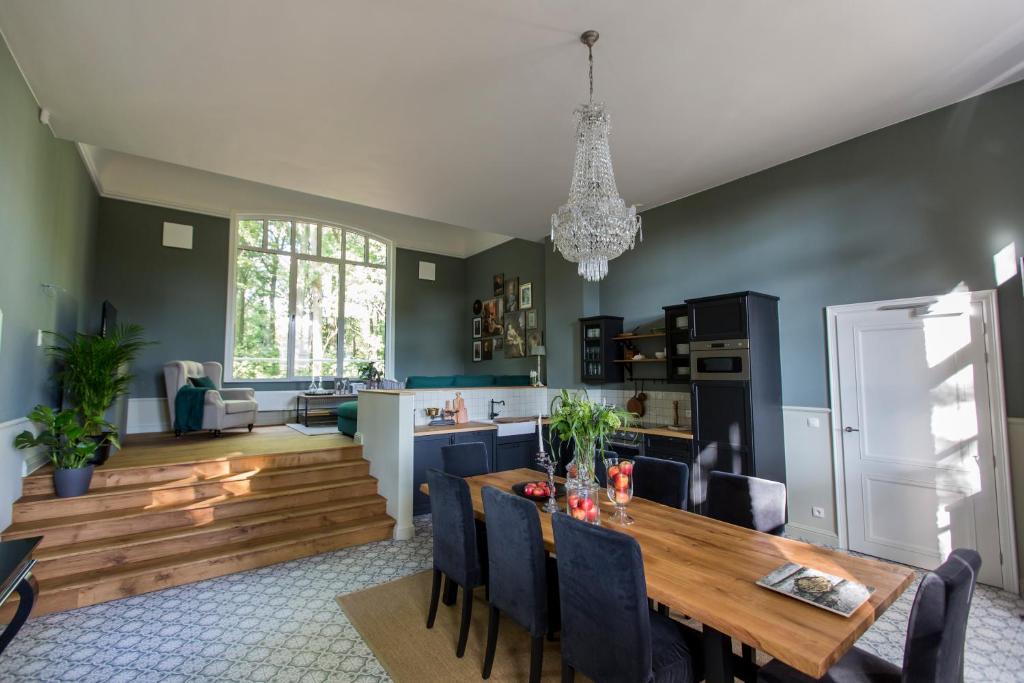 uma cozinha e sala de jantar com uma mesa de madeira e cadeiras em Antonine's Atelier em Hingene