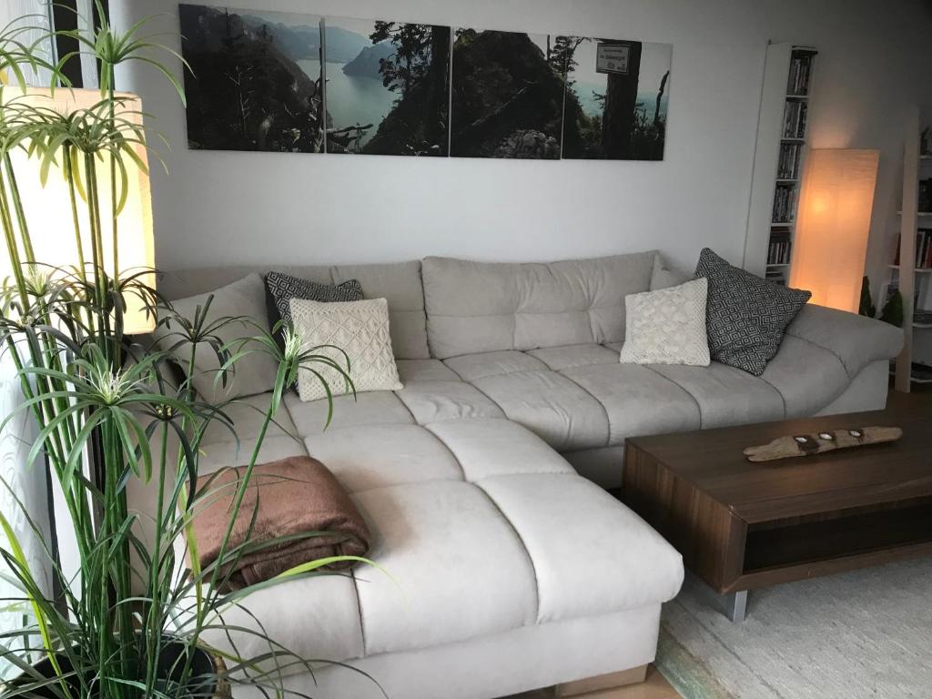 a white couch in a living room with plants at Apartment Parkvilla Traunsee in Altmünster