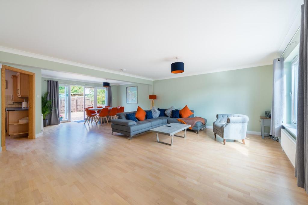 a large living room with a couch and chairs at 4 Kinnessburn Cottages in St. Andrews