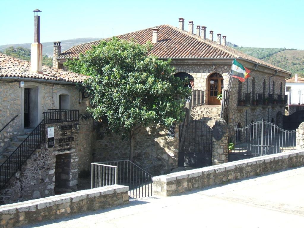 ein Steinhaus mit einem Zaun davor in der Unterkunft Hotel Rural El Convento in Valencia de Alcántara