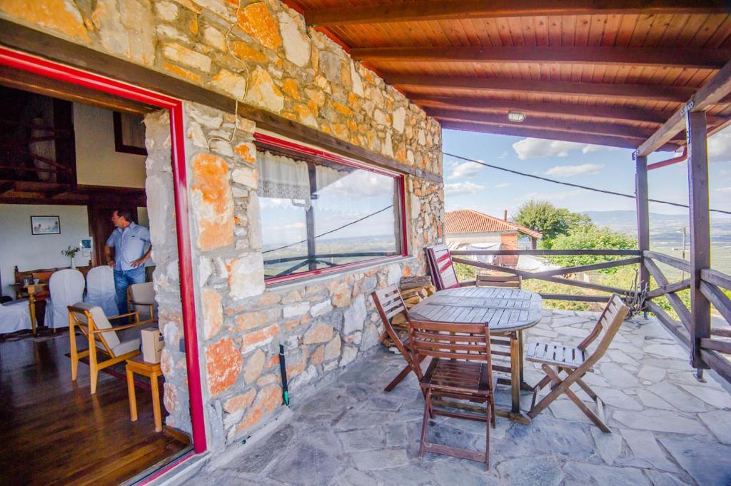 a stone house with a table and chairs on a balcony at Stonehouse 2 Bedroom Chalet on Olympus Amazing View in Pétra