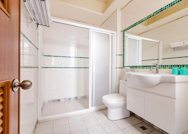 a bathroom with a shower and a toilet and a sink at Eik Forest B&amp;B in Taitung City