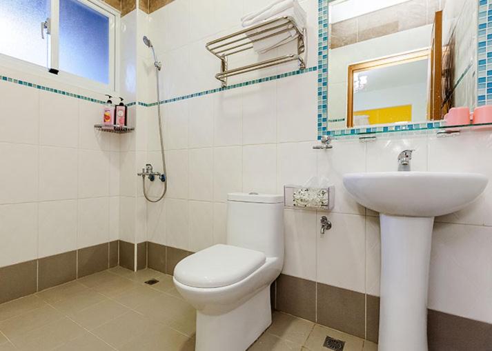 a bathroom with a toilet and a sink at Eik Forest B&amp;B in Taitung City