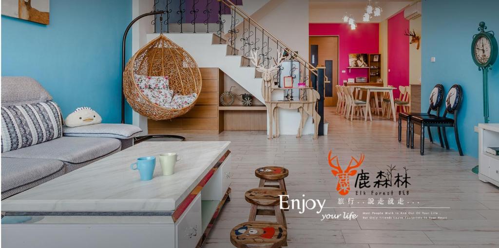 a living room with a couch and a staircase at Eik Forest B&amp;B in Taitung City