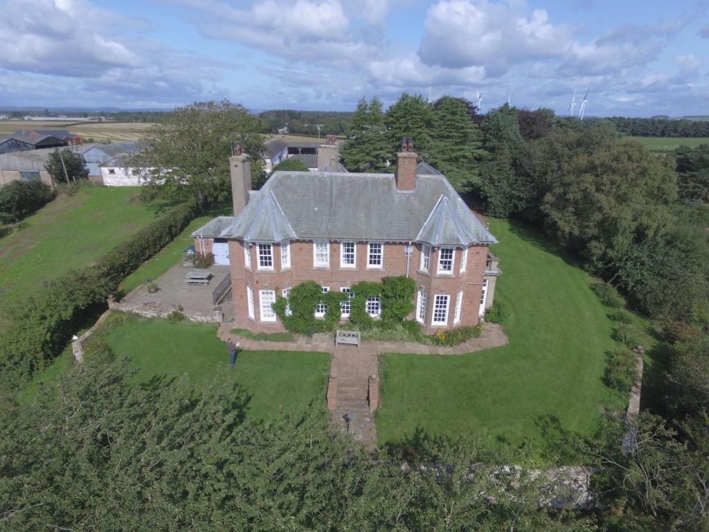 an aerial view of a large house on a green field at Clift Hill in Carlisle