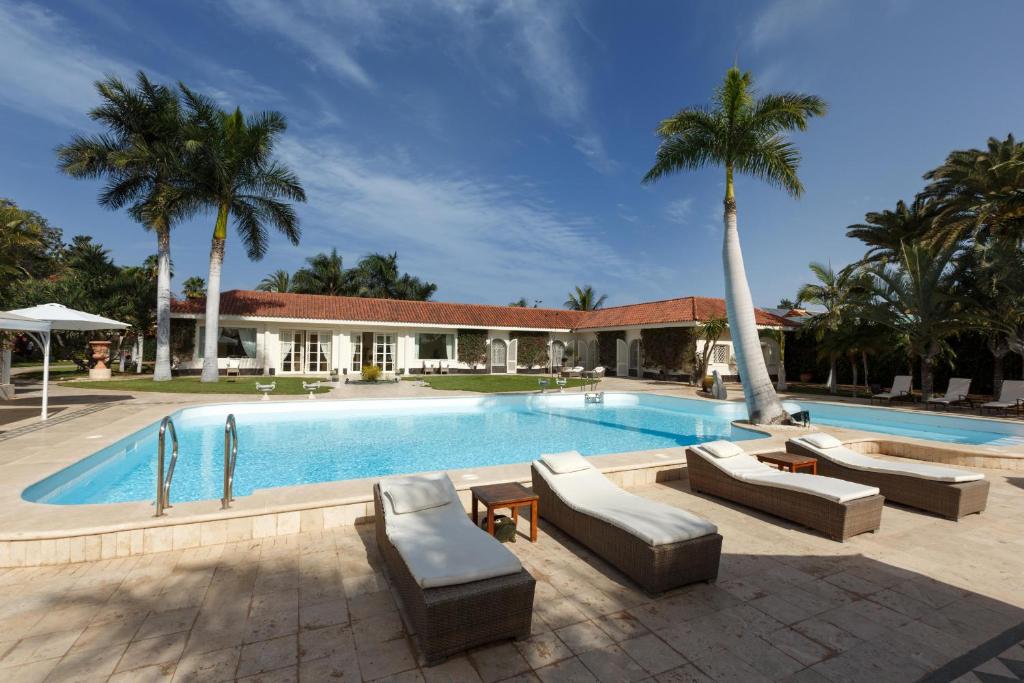 - une piscine avec des canapés et des palmiers à côté d'une maison dans l'établissement Magnificent Villa Piera, à Maspalomas