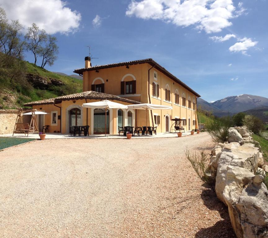 a large house with a gravel road in front of it at il casale san martino in Norcia