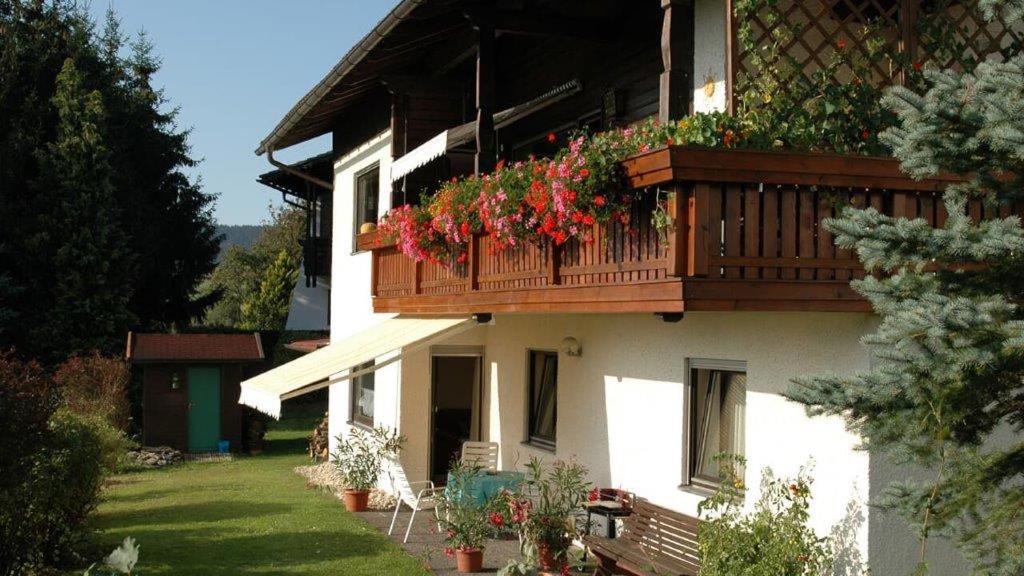 a house with a balcony with flowers on it at Ferienwohnung Stilla Traurig in Arrach