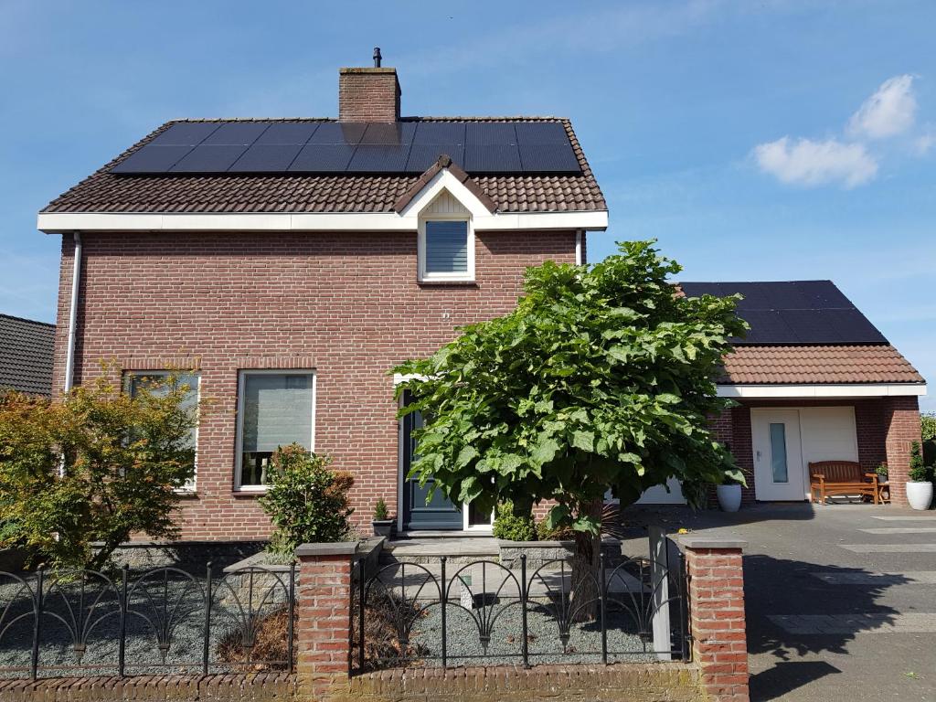una casa con paneles solares en el techo en Het Gildehuis met sauna en jacuzzi, en Stevensweert