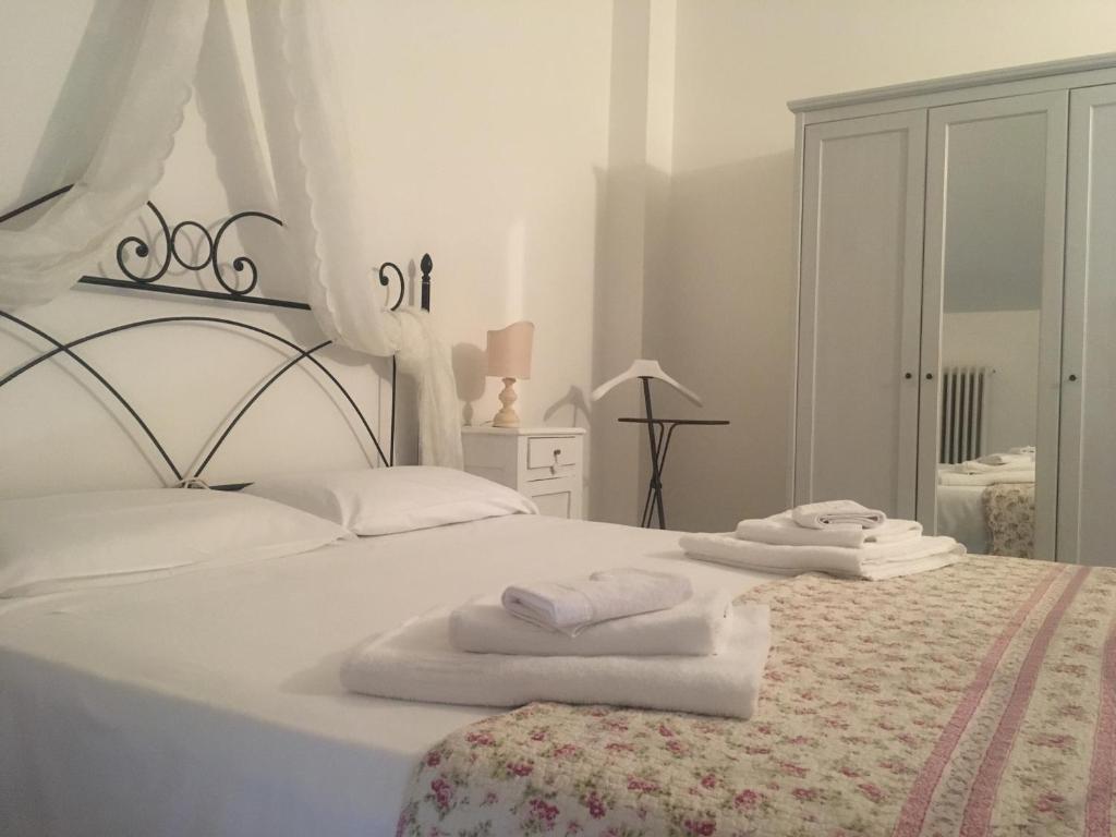 een witte slaapkamer met witte handdoeken op een bed bij B&B Casa Dolce Casa in Verona