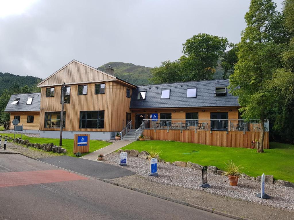 a large brick building with a clock on the side of the building at Glen Nevis Youth Hostel in Fort William