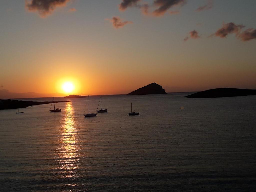 a group of boats in the water at sunset at Kalos Gialos Sunrise Apartment in Porto Rafti