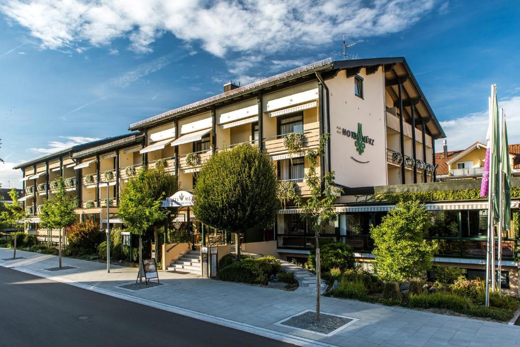 un edificio en una calle con árboles delante en Wunsch Hotel Mürz - Natural Health & Spa Hotel, en Bad Füssing