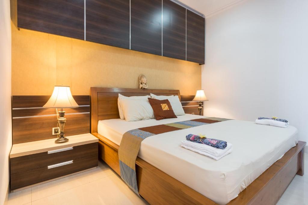a bedroom with a bed and a nightstand with a lamp at Villa Melasti Wardana in Uluwatu