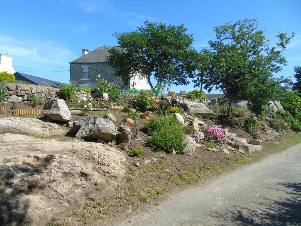 um jardim com pedras e flores ao lado de uma estrada em Location Keransignour em Concarneau