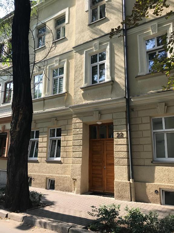 budynek z drewnianymi drzwiami i drzewem w obiekcie Jacuzzi & Bike Apartment, Krakow w Krakowie