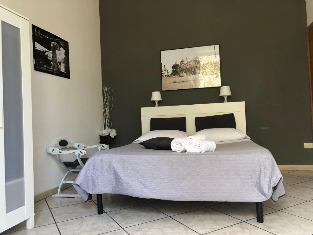 1 dormitorio con 1 cama y 2 toallas blancas en Platamone Rooms, en Catania