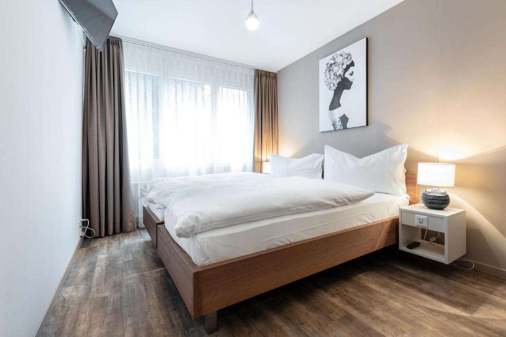 ein Schlafzimmer mit einem großen Bett und einem Fenster in der Unterkunft Hotel Birsighof Basel City Center in Basel