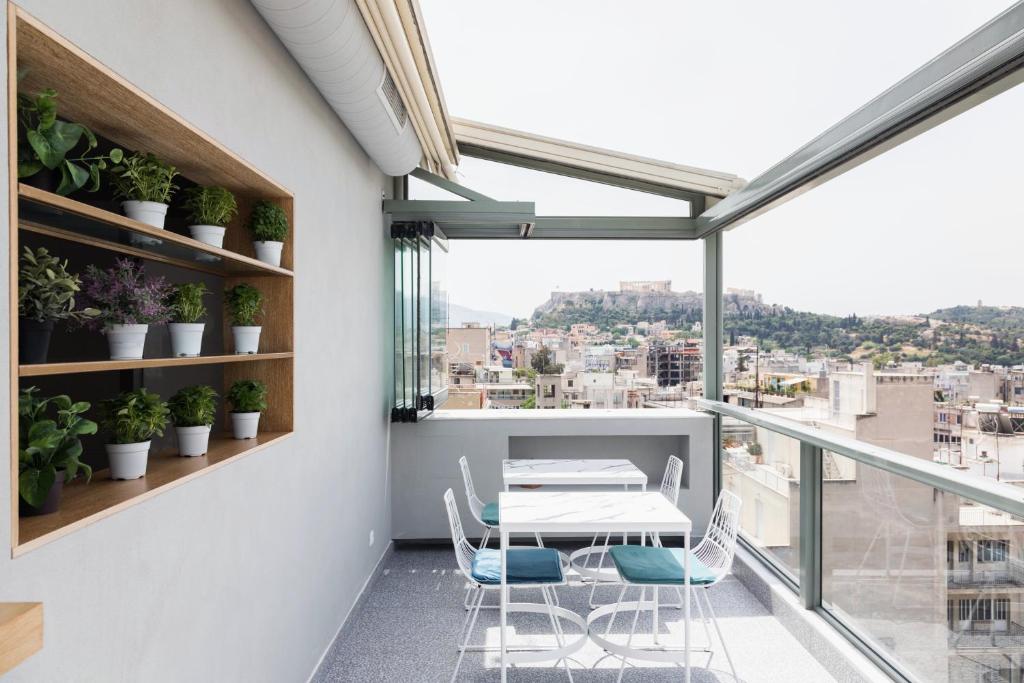 Apartment mit einem Balkon mit Tisch und Stühlen. in der Unterkunft Evripides Hotel in Athen
