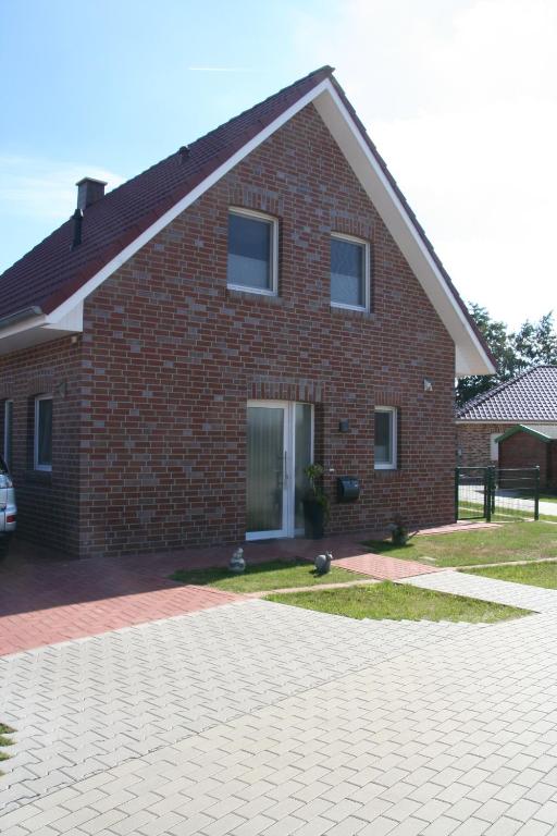 a brick house with a driveway in front of it at Ferienhaus Seepark in Walchum