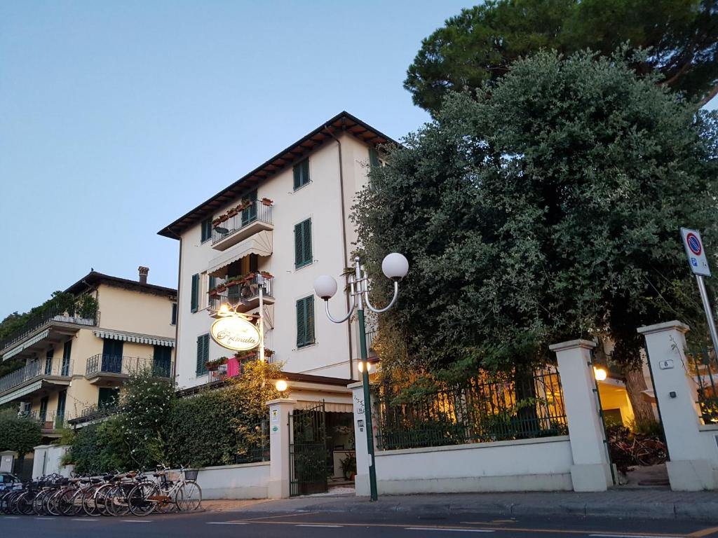 a building with a clock on the side of a street at Hotel La Primula in Forte dei Marmi