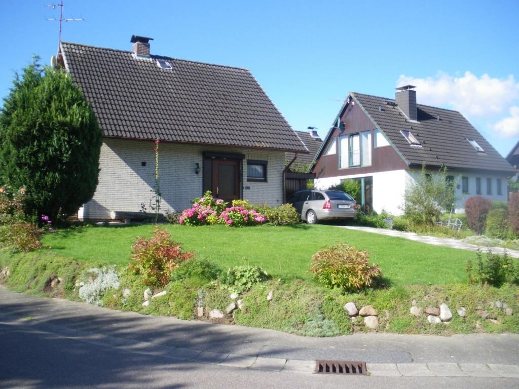 a house with a green yard with a driveway at Haus Waterblick in Waabs