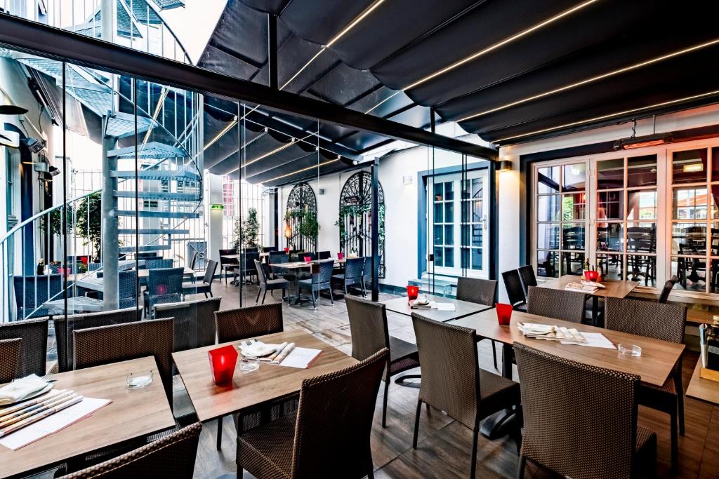 a restaurant with wooden tables and chairs and windows at XII Apostel Albergo in Cologne