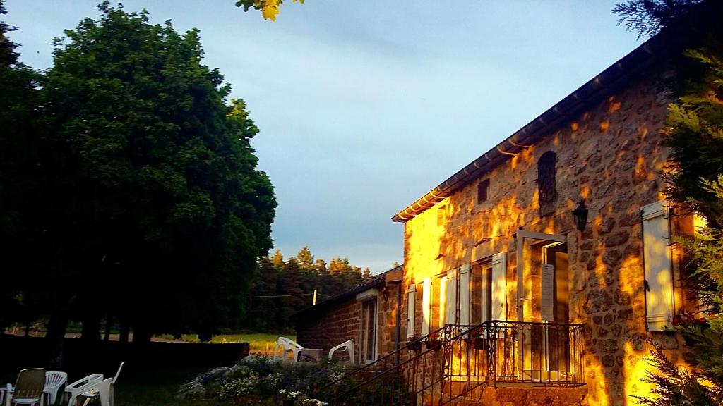 an old stone building with chairs outside of it at Domaine de Rilhac in Saint-Agrève