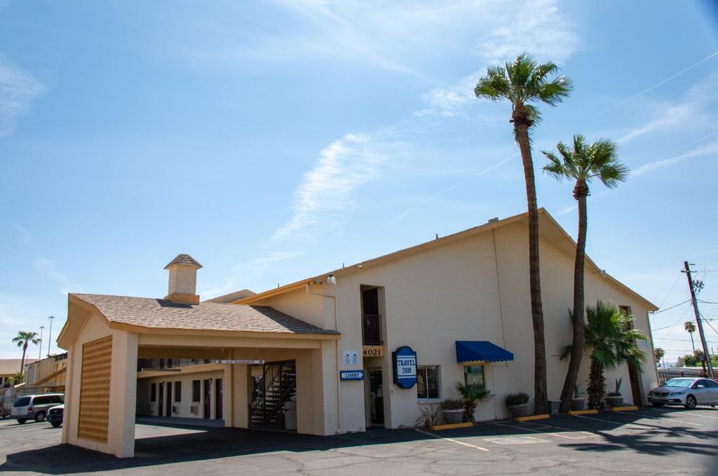 un edificio con dos palmeras delante en Travel Inn, en Phoenix