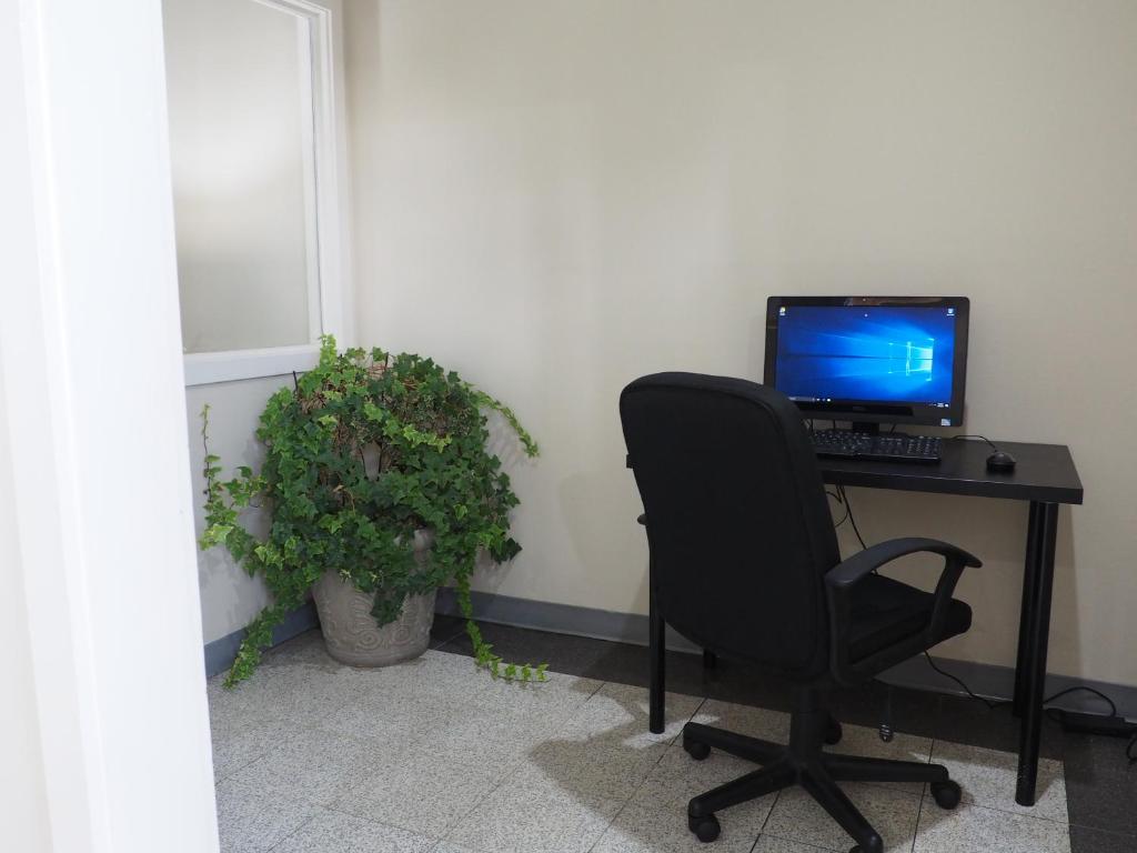 a desk with a computer monitor and a chair at Parkview Inn and Conference Center in Allentown