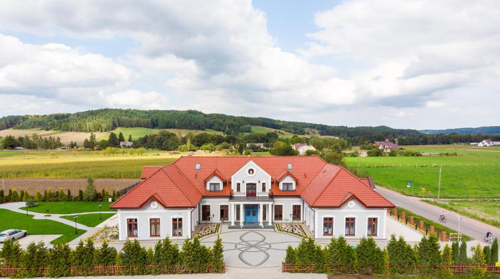 a large white house with a red roof at Dworek Czardasz Strzebielino - Wejherowo in Strzebielino