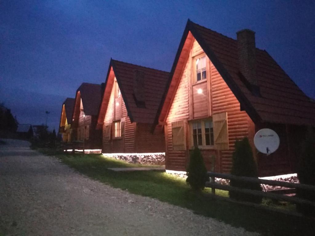 a row of wooden houses on a street at night at Lodge Nagramak in Sekulić 