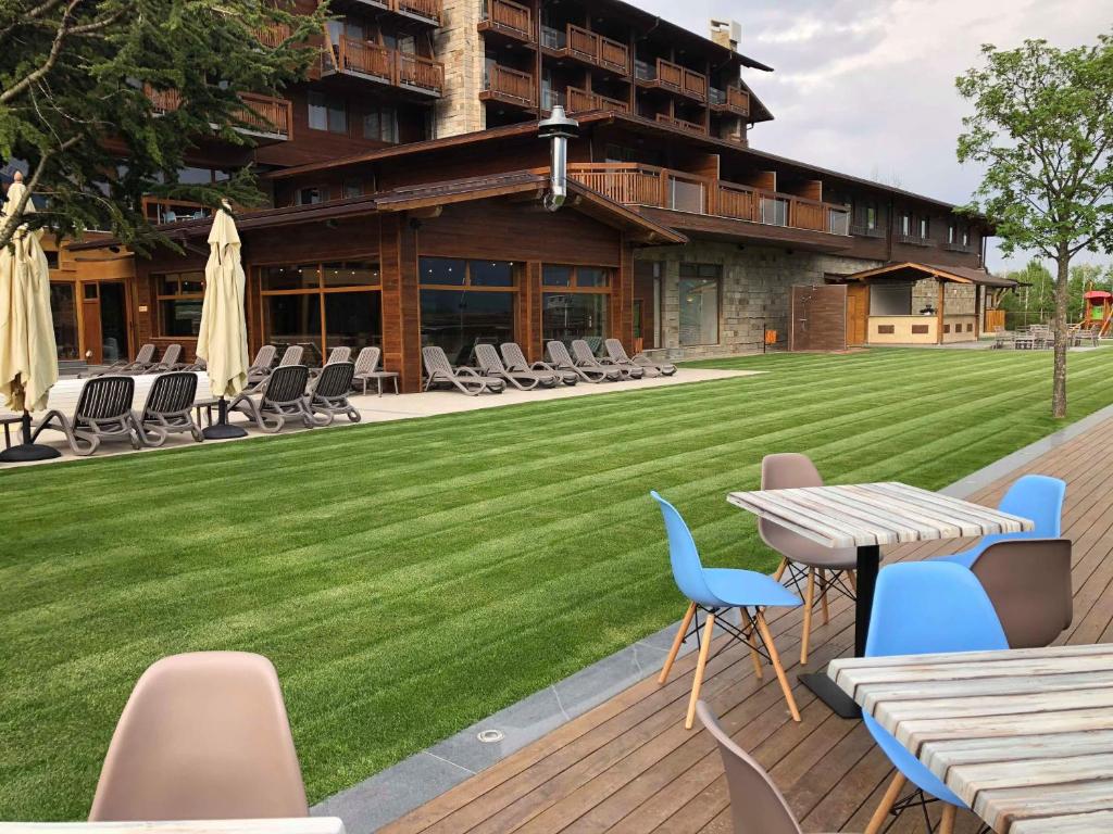 a patio with a lawn and a table and chairs at Вила Комплекс Катарино in Razlog