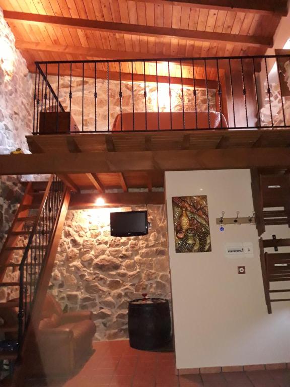 Cama elevada en habitación con pared de piedra en Loft Rural Corte de Fora en Ourense
