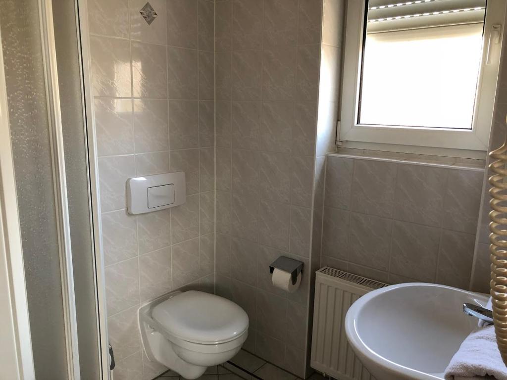a small bathroom with a toilet and a sink at Pension Preussenstraße Leipzig in Leipzig