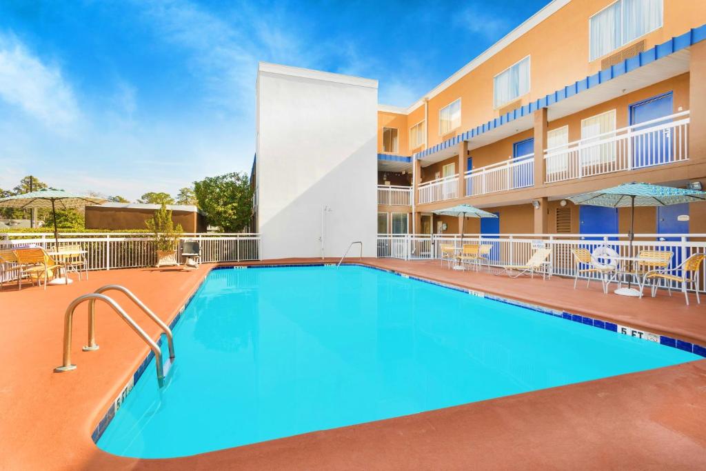 a swimming pool in front of a hotel at Baymont by Wyndham Savannah Midtown in Savannah