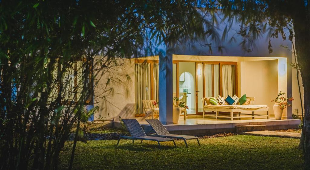 een huis met twee stoelen en een bank in een tuin bij The Zubeida Boutique Resort in Diani Beach