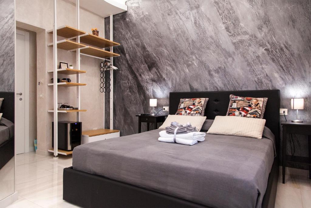 een slaapkamer met een groot bed met een grijze muur bij Silver house in La Spezia