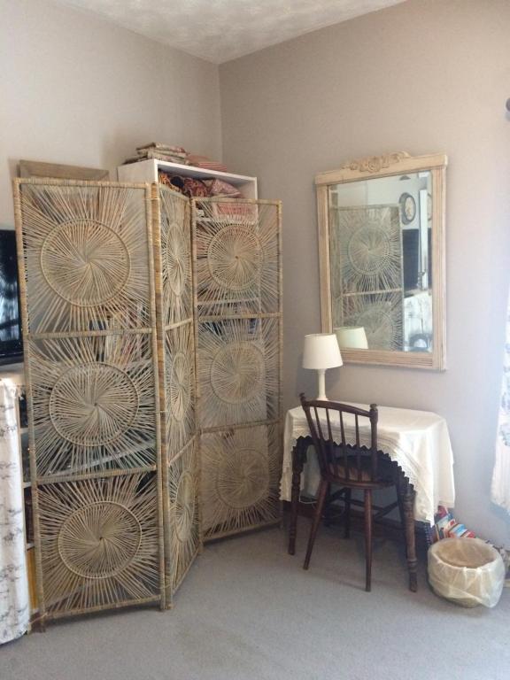 a room with a table and a dresser with a mirror at Stylish room near seafront in Cleethorpes