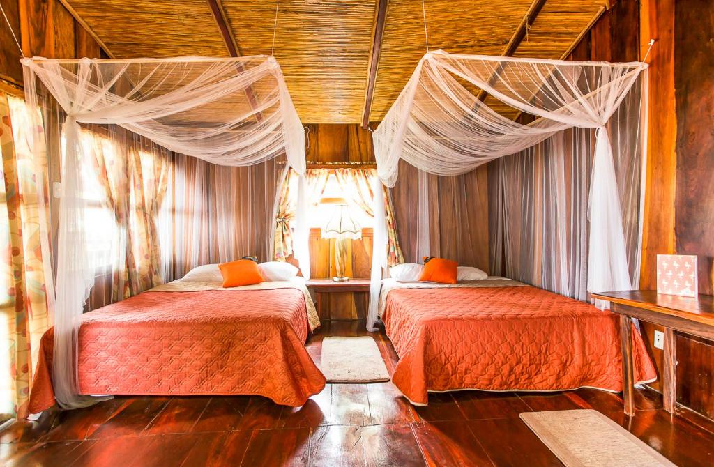 a bedroom with two beds with curtains on them at Redwood Beach Resort in Mechapa