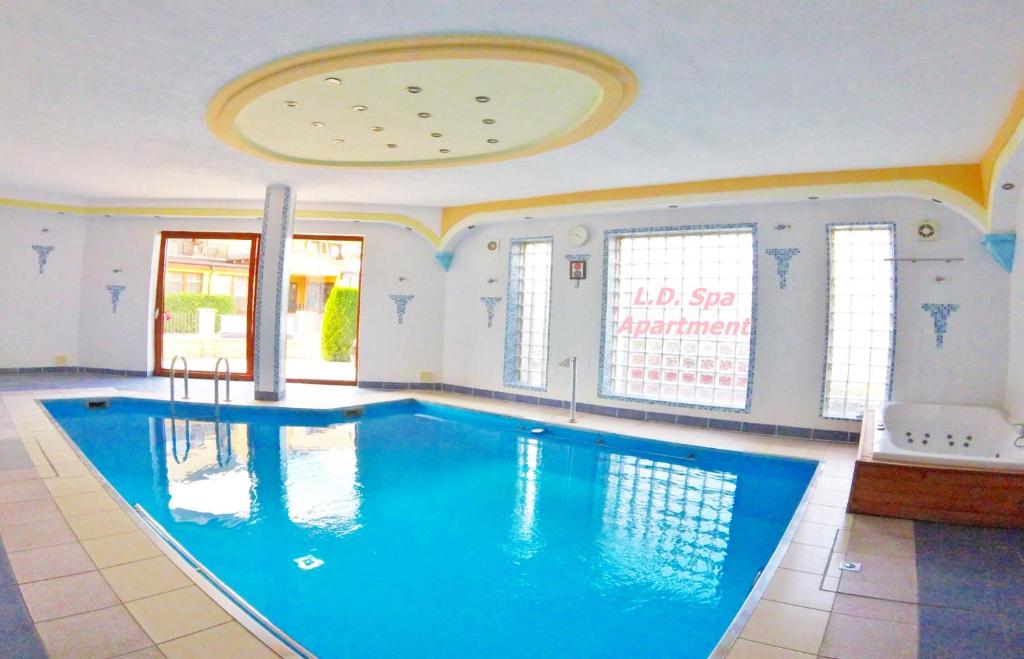 a large swimming pool in a room with a ceiling at L.D. SPA Apartment in Rewal