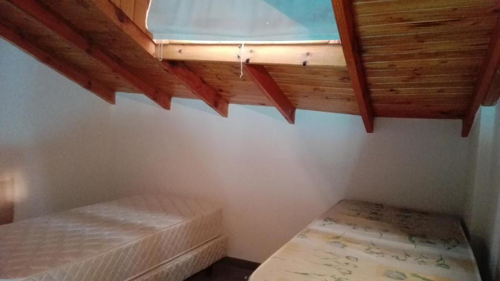 1 dormitorio con cama y techo de madera en Tehuelches Familiar en Puerto Madryn