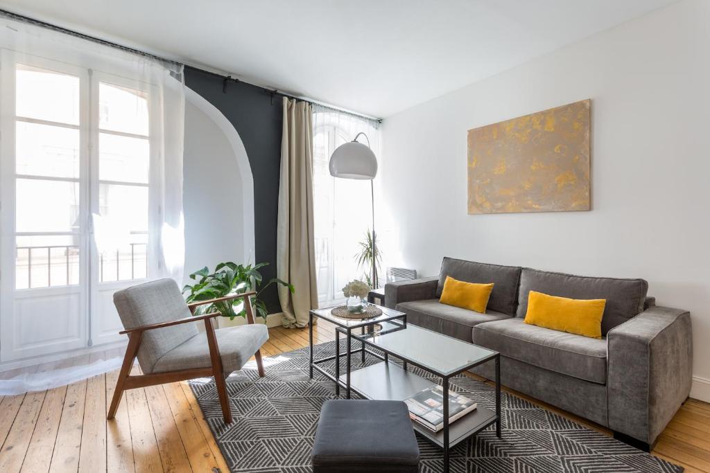 ein Wohnzimmer mit einem Sofa und einem Tisch in der Unterkunft Bordeaux Bouquiere in Bordeaux