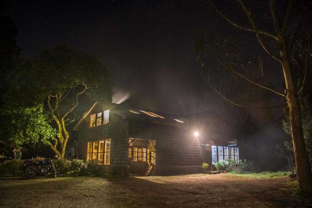 Una casa de noche con una luz encendida en Hostal Climb House, en Puerto Varas