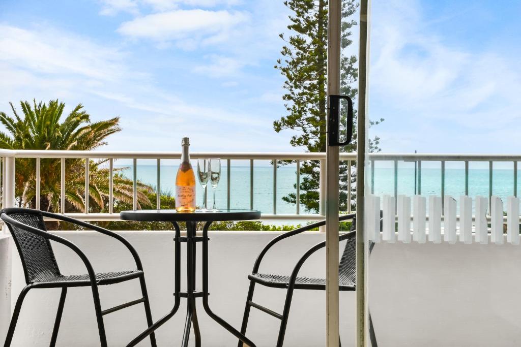 a table and chairs on a balcony with the ocean at Alex Beach Apt Bilgola4 in Alexandra Headland