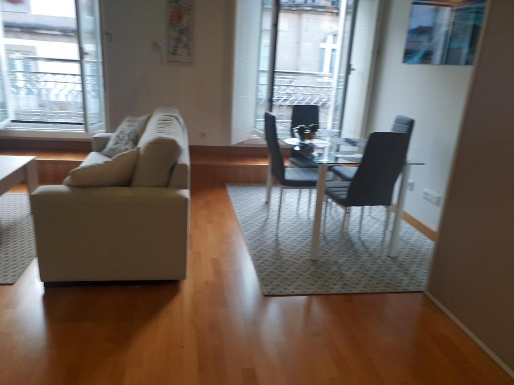 sala de estar con sofá, mesa y sillas en Loft Velázquez Moreno 35, en Vigo