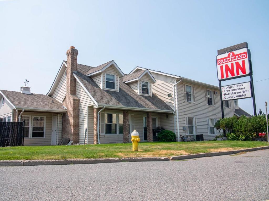 un boucher jaune d'incendie devant une maison dans l'établissement The Ranchland Inn Kamloops, à Kamloops