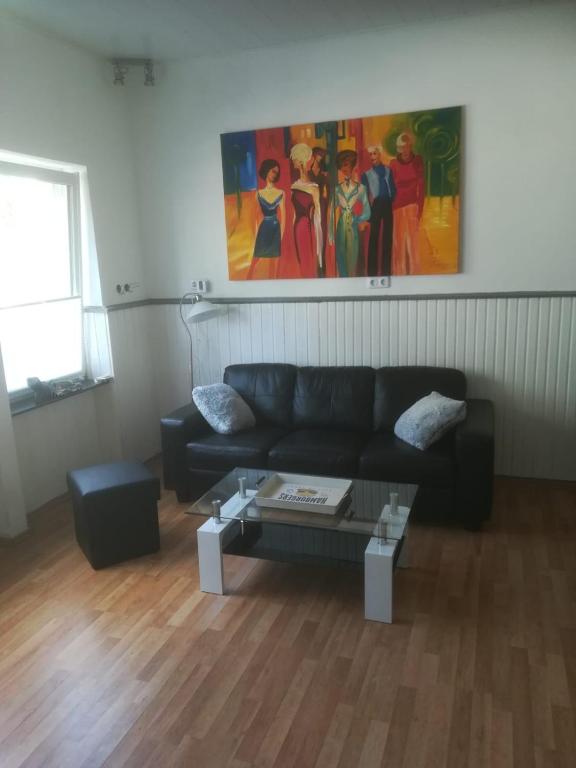 uma sala de estar com um sofá preto e uma mesa em Zentral gelegene Wohnung in Velbert-Mitte em Velbert