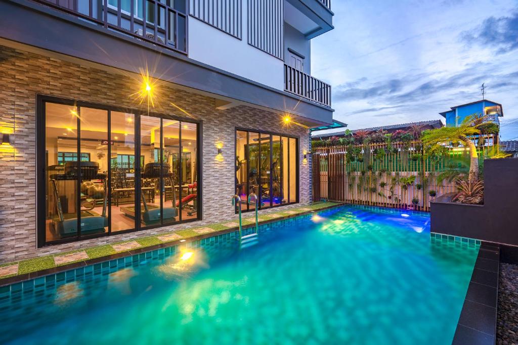 a swimming pool in the backyard of a house at Penyos Residence in Bangkok